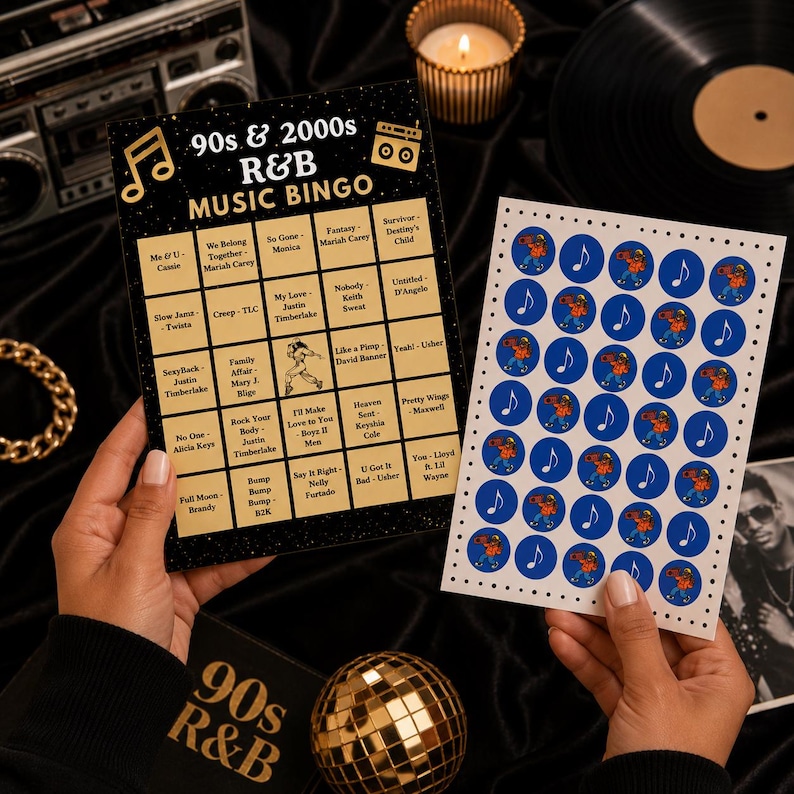 May include: A 90s & 2000s R&B Music Bingo game card with a black background and gold text, featuring a grid of song titles and artists. Beside it is a white sheet of circular blue stickers with musical note and dancer graphics for marking squares.
