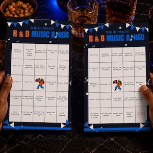 Może przedstawiać: Dwie prostokątne karty do gry zatytułowane The Ultimate R&B Music Bingo z ciemnoniebieskim tłem, białą siatką i niebieskimi chorągiewkami. Każda karta zawiera listę tytuł&oacute;w piosenek i wykonawc&oacute;w oraz małą ilustrację postaci w środku.