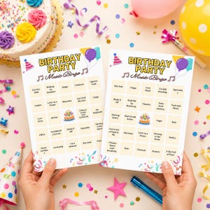 May include: Two rectangular birthday party music bingo cards featuring a grid of song titles, a central birthday cake illustration, and the text 'BIRTHDAY PARTY Music Bingo' at the top, decorated with colourful balloons and party hat graphics.