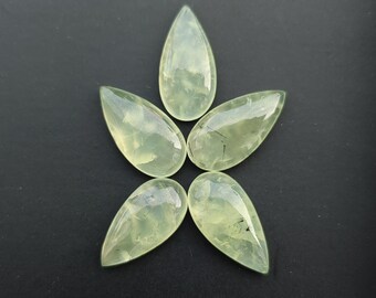 May include: Five pear-shaped, translucent green prehnite gemstones arranged in a starburst pattern against a dark background. Each stone has a smooth, polished surface with subtle internal inclusions, and a teardrop shape.