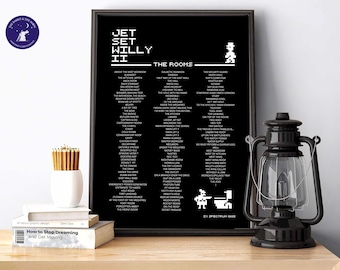 May include: Black framed print featuring the text "JET SET WILLY II" and a list of rooms. The print has pixelated graphics and is displayed on a wooden surface with a black lantern, books, and pencils.