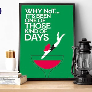 May include: A framed art print with the text "WHY NOT... IT'S BEEN ONE OF THOSE KIND OF DAYS" in white on a green background. The image features a person diving into a red liquid in a wine glass.