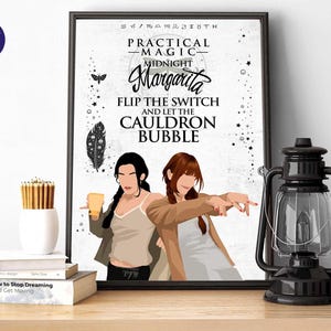 May include: A framed wall art print featuring two illustrated figures, a moth, a feather, and the text: Practical Magic, Midnight Margarita, Flip the switch and let the cauldron bubble. The design includes zodiac symbols and stars on a white background.