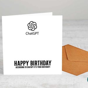 Op de afbeelding: Een witte wenskaart met de tekst "HAPPY BIRTHDAY ACCORDING TO CHATGPT IT'S YOUR BIRTHDAY!" en het ChatGPT-logo. Een bruine envelop ligt naast de kaart.