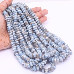 May include: A strand of blue, white and grey banded agate beads. The beads are oval shaped and have a smooth, polished finish.