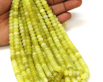 May include: A strand of light green jade beads. The beads are round and smooth, and they are strung on a clear thread.