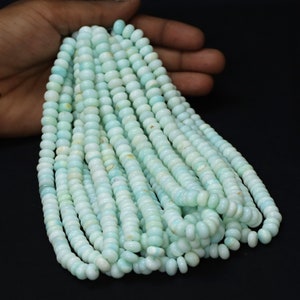 May include: A strand of light blue opal beads. The beads are round and have a smooth, polished finish. The strand is approximately 18 inches long.