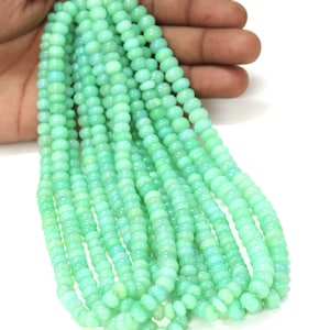 Peut inclure: Un brin de perles de pierres précieuses vert clair. Les perles sont rondes et lisses, et elles sont enfilées sur un fil transparent. Les perles mesurent environ 4 mm de diamètre.