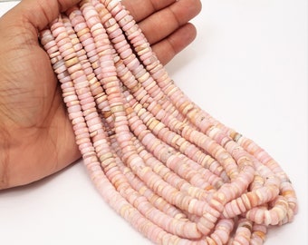 Pode incluir: Um fio de contas de opala rosa, cada conta é um disco plano e redondo com uma forma ligeiramente irregular. As contas são enfiadas em um fio transparente e têm aproximadamente 6 mm de diâmetro.