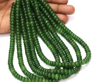 May include: A strand of green jade beads, approximately 6mm in diameter, strung on a clear thread. The beads are smooth and polished, with a slightly translucent appearance.