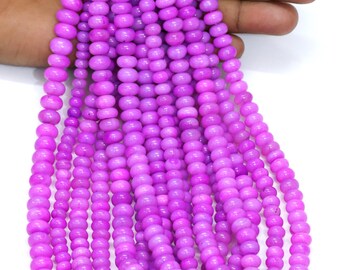 Puede incluir: Una hebra de cuentas de piedras preciosas de color púrpura. Las cuentas son redondas y lisas, y tienen un ligero brillo iridiscente.