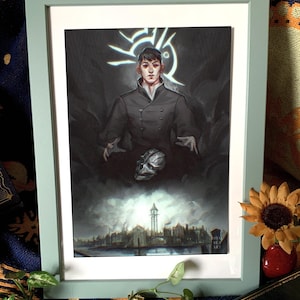 Puede incluir: Impresión artística enmarcada que representa a una persona con abrigo negro, con un símbolo estilizado sobre su cabeza. La obra de arte incluye un paisaje urbano y una máscara metálica. El marco es de color verde claro.