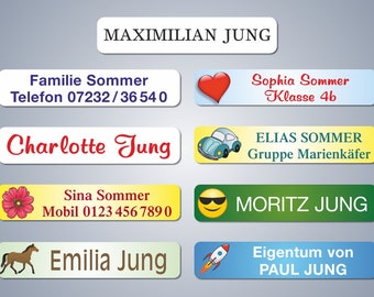May include: A collection of rectangular name labels with various names and designs. The labels include names like Maximilian Jung, Charlotte Jung, and Moritz Jung. Some labels feature illustrations such as a heart, car, and rocket.