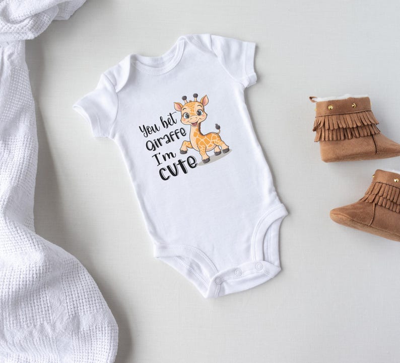 May include: White baby onesie with a cute cartoon giraffe and the text "You bet Giraffe I'm cute".