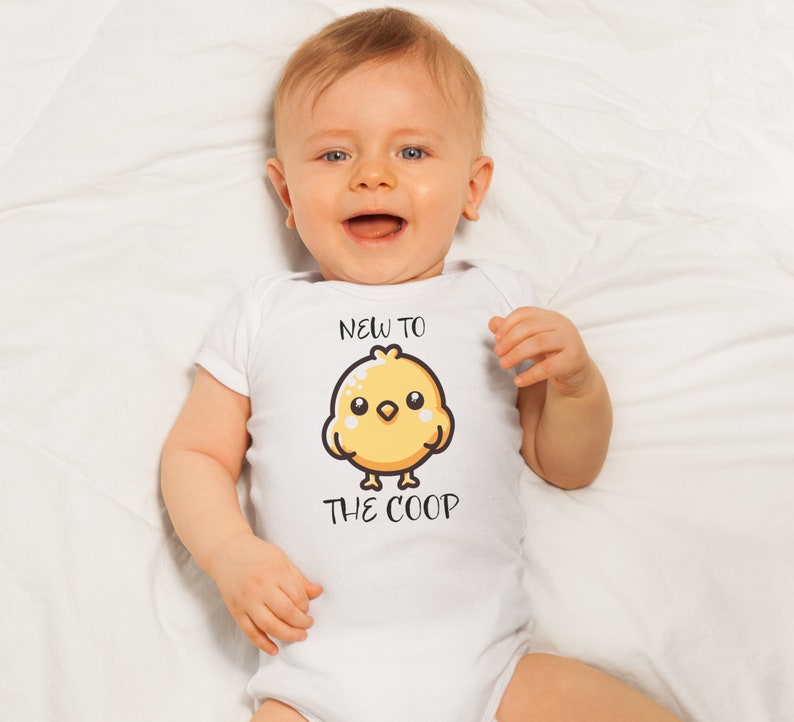 May include: A white baby onesie with a yellow chick cartoon and the text "New to the coop".