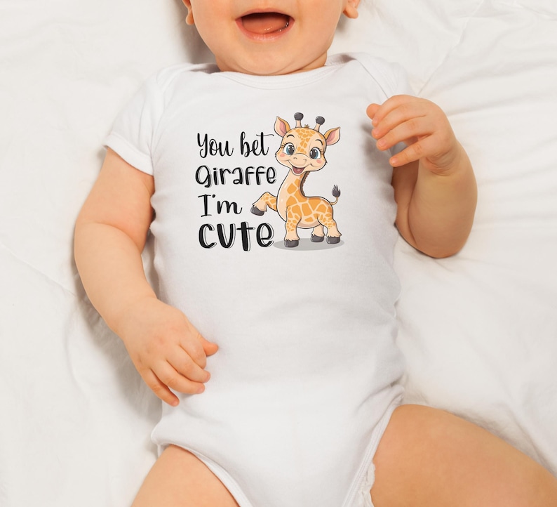 May include: White baby onesie with short sleeves featuring a cartoon giraffe with the text "You bet giraffe I'm cute".