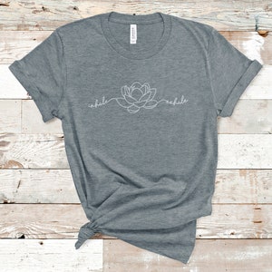 May include: A heather gray t-shirt with a white outline of a flower and the words "inhale" and "exhale" on the front.