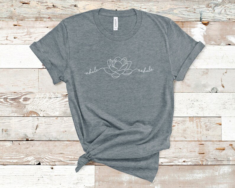 May include: A heather gray t-shirt with a white outline of a flower and the words "inhale" and "exhale" on the front.