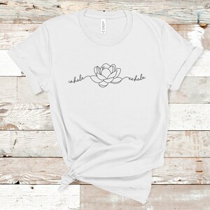 May include: White t-shirt with a black line drawing of a lotus flower and the words "inhale" and "exhale" on either side of the flower.