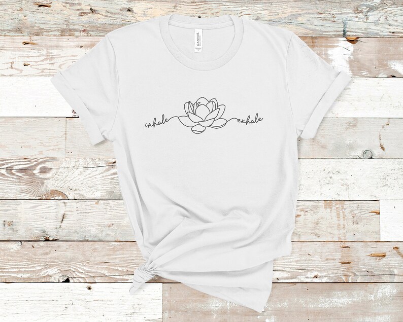 May include: White t-shirt with a black line drawing of a lotus flower and the words "inhale" and "exhale" on either side of the flower.