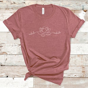 May include: A maroon t-shirt with a white outline of a flower and the words "inhale" and "exhale" on the front.