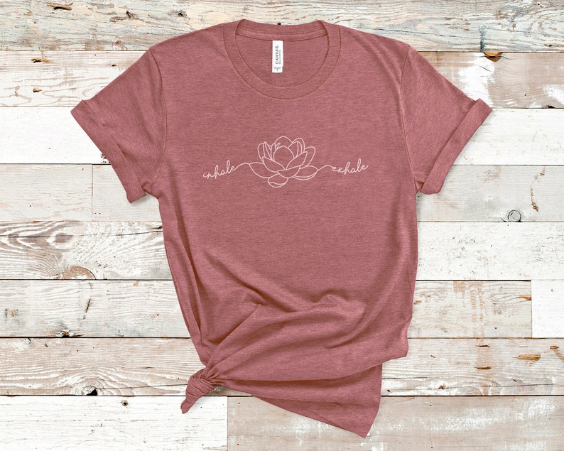 May include: A maroon t-shirt with a white outline of a flower and the words "inhale" and "exhale" on the front.