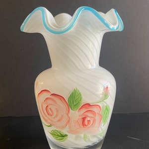Puede incluir: Jarrón de vidrio blanco con un borde azul rizado y rosas rosas pintadas a mano con hojas verdes.