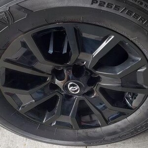 May include: Black tire with a black rim and a black five-spoke wheel. The tire has the text "P265/65R17" on the side.