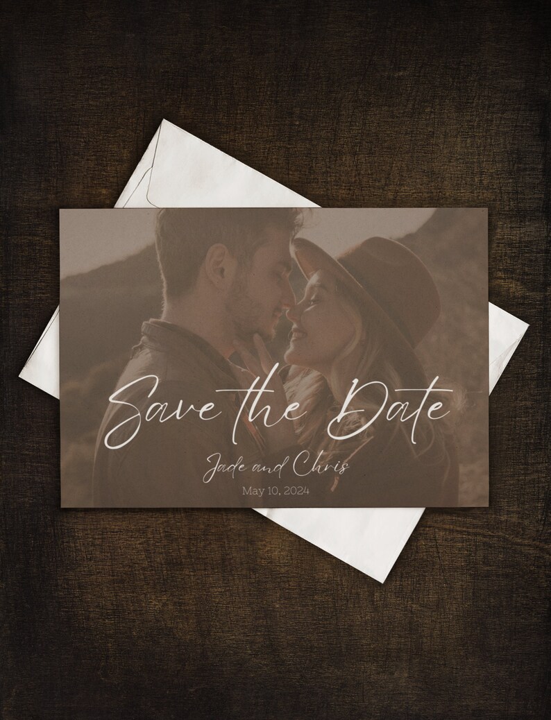May include: A save the date card featuring a sepia-toned photograph of a couple embracing. The card includes the text "Save the Date" in elegant script, along with the names "Jade and Chris" and the date "May 10, 2024". The card is placed on a dark wooden surface.