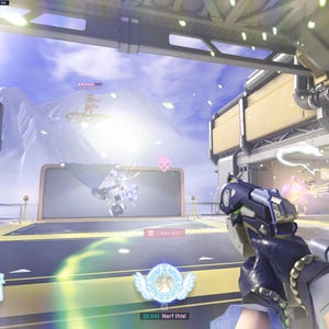May include: A first-person view of a video game scene. The player is holding a gun and aiming at an enemy. The enemy is a robot with a blue and white color scheme. The game is set in a futuristic city with a snowy mountain in the background. The game's user interface is visible in the lower left corner of the screen. The text "175 175" is displayed on the user interface.