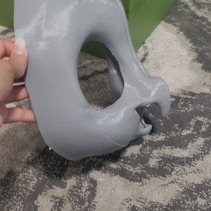 May include: A gray, 3D printed, unfinished mask with a large eye hole and a small nose hole.