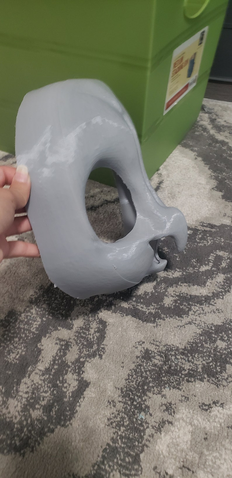 May include: A gray, 3D printed, unfinished mask with a large eye hole and a small nose hole.