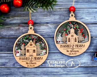 May include: Two wooden Christmas ornaments with a house and church design, filled with glitter and small red accents. The ornaments are inscribed with "Married & Merry" and names with dates. Each ornament is approximately 3 inches in diameter.