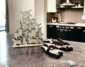 May include: A wooden puzzle featuring a stack of 12 cat silhouettes. The puzzle pieces are arranged in a pyramid shape, with the largest piece at the bottom and the smallest piece at the top. The puzzle is labeled "Puppy Pile-Up".