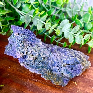 May include: A purple and blue agate geode with a rough, textured surface. The geode is a natural formation with a variety of colors and patterns.