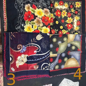 May include: Four black square scarves with different floral and geometric patterns. The scarves have a crocheted border with red and white accents.