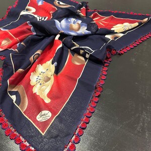 May include: A blue and red floral patterned scarf with a crocheted trim. The scarf has a label that reads "Ipsece" and "Lalezar" made in Turkey.