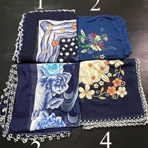 May include: Four blue square scarves with white lace trim and different floral patterns. The scarves are numbered 1 through 4.