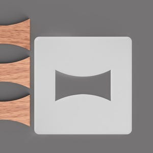 Könnte beinhalten: Vier hölzerne Kerzendochte und eine weiße quadratische Schablone mit einer geschwungenen Sanduhrform. Die Dochte sind hellbraun und die Schablone ist weiß. Der Hintergrund ist einfarbig grau.
