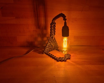 Upcycled steel desk lamp made from nuts welded together to form an unusual table light. Unique decorative mood lighting, metal art piece.