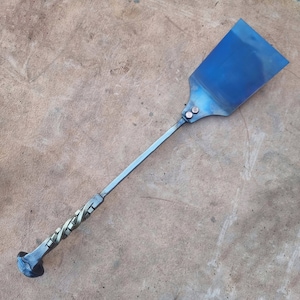 Peut inclure: Une spatule en métal bleu avec un manche torsadé. Le manche est en métal et présente un motif torsadé décoratif. La spatule mesure environ 50 cm de long.