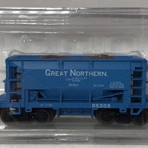 May include: A blue model train car with the words "Great Northern" printed on the side. The model train car is in a clear plastic case. The model train car is a miniature replica of a freight car.