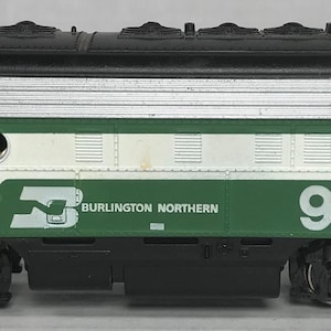 May include: Green and white model train locomotive with the number 9760 and the words "Burlington Northern" printed on the side.