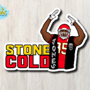 May include: A red and black football jersey with the number 35 and the name "Jones" on the back. The jersey has a black vest with a skull design. The text "Stone Cold" is written in yellow and red letters below the jersey.
