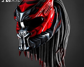 May include: A glossy red and black motorcycle helmet featuring the text XBow. The helmet has a dark visor, a sculpted faceplate with metallic accents, and long black braided cords hanging from the back, each tipped with a pointed red spike.
