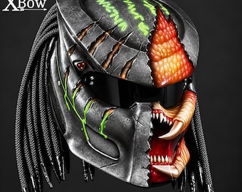 May include: A full-face motorcycle helmet featuring a dark metallic finish with textured, reptilian-like orange and red scales on the right side, green glowing symbols on top, and long black braided cords. The XBow logo is visible in the top left corner.
