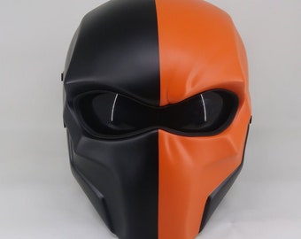 May include: A black and orange motorcycle helmet with a visor. The helmet is half black and half orange, with a sharp line dividing the two colors.