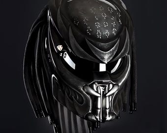 Può includere: Un casco da moto nero con un design Predator. Il casco è dipinto di nero e argento con una maschera facciale Predator dettagliata. Il casco ha una visiera nera e un cinturino nero.