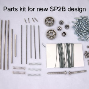 May include: Parts kit for a new SP2B design. The kit includes metal rods, springs, screws, bearings, string, and a hex wrench.