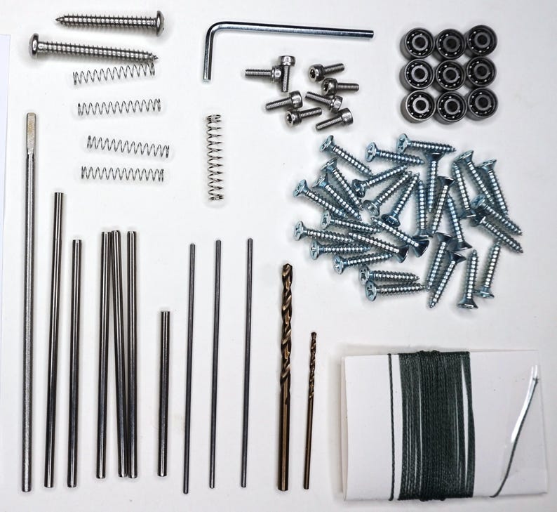 May include: Assortment of hardware supplies including screws, springs, metal rods, drill bits, bearings, and a spool of string.